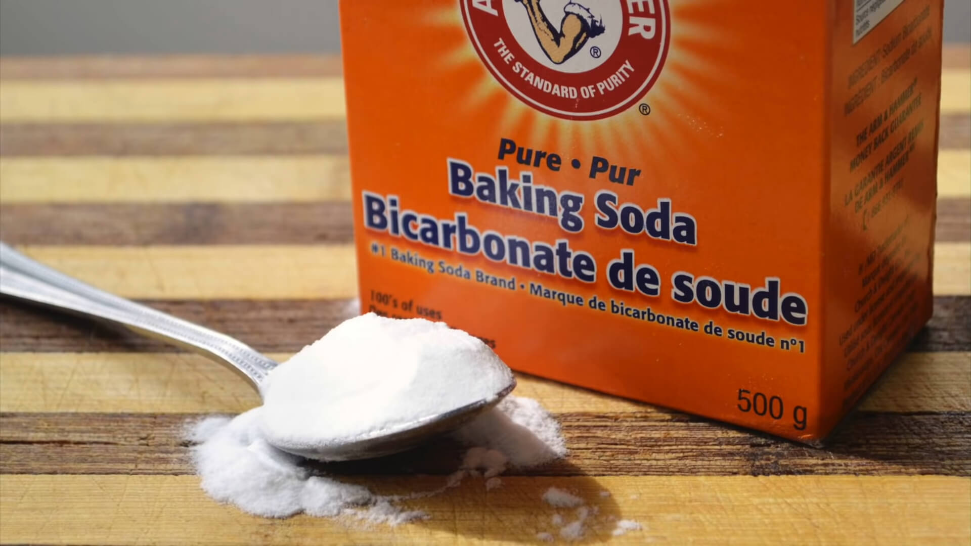 A box of baking soda with a teaspoon of soda next to it