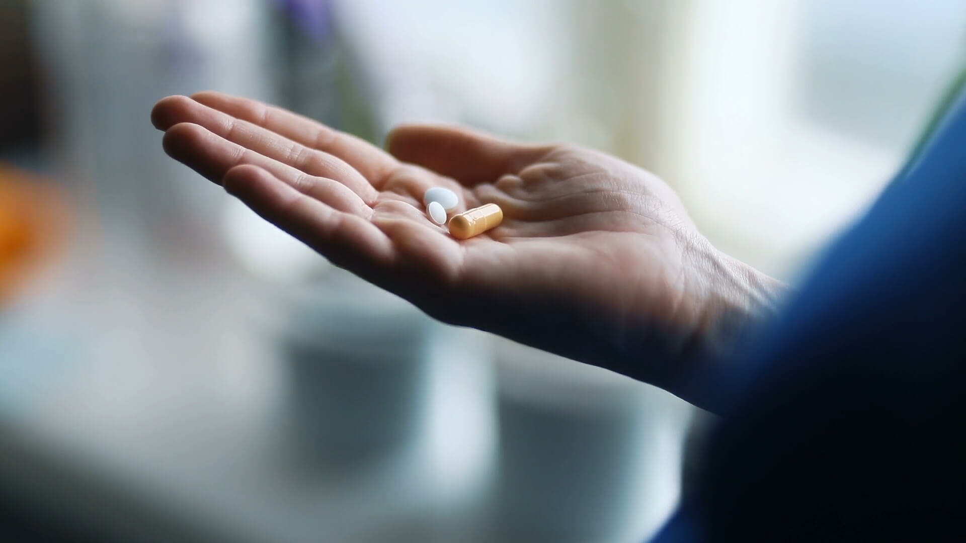 A woman's hand holding pain relief medication