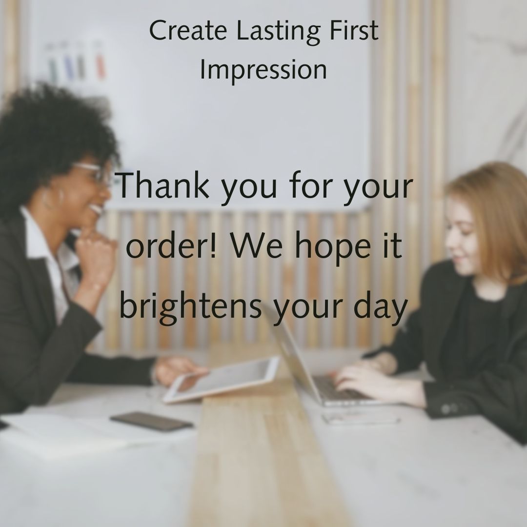 Two women at a table exchanging a thank you message for an order