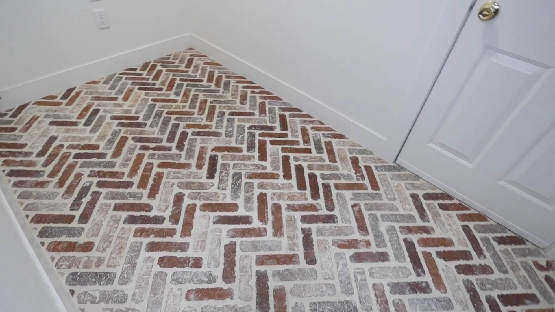 Red bricks with white grout installed in a small room