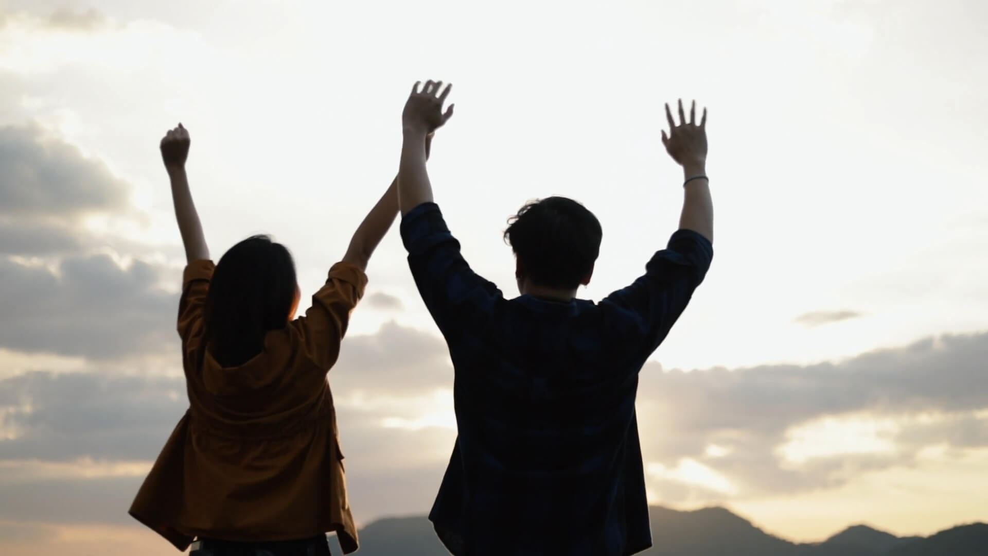 A couple raises their arms in celebration