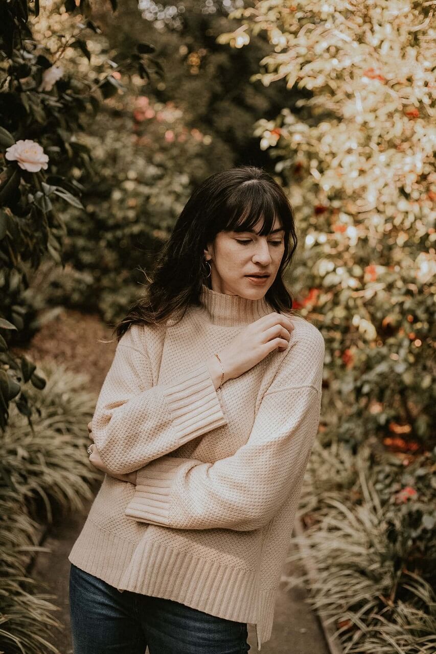 Woman trying on Everlane Oversized Stroopwafel Turtleneck