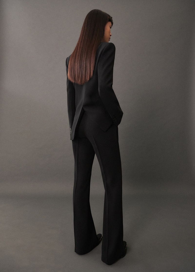 Woman wearing black wide-leg trousers paired with a matching black blazer