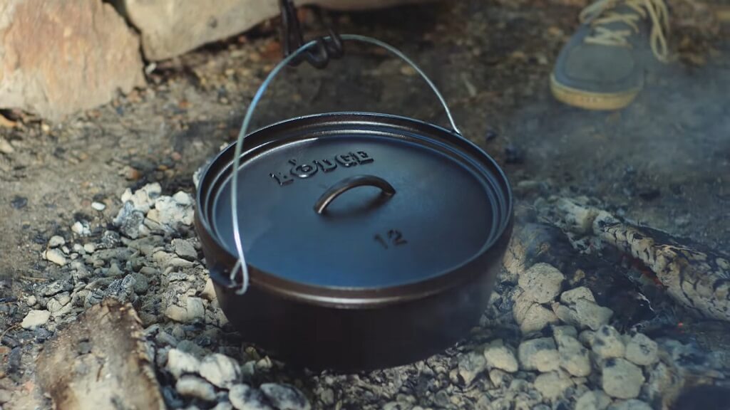 Cast iron pot heating over a campfire