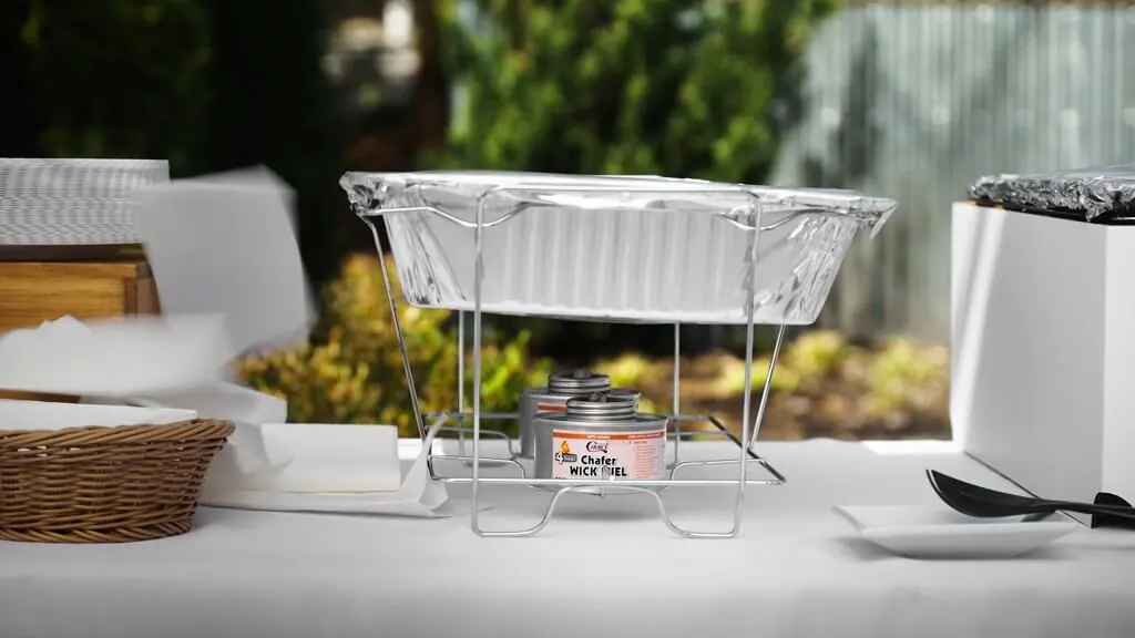 A wire rack holding a foil chafing dish with a small fuel canister below it