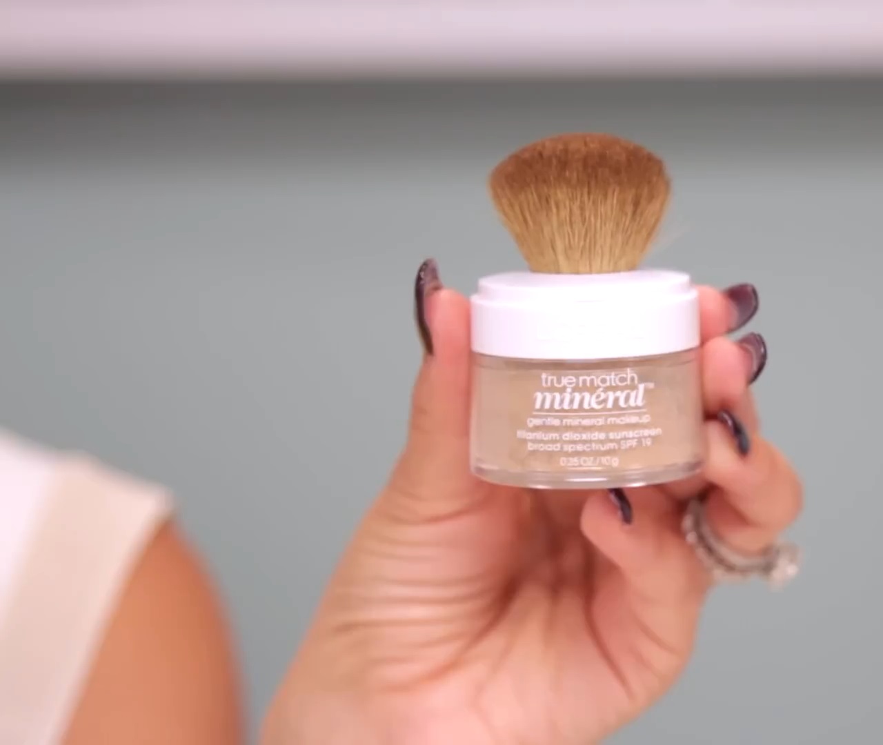 Close-up of a hand holding the L’Oréal True Match Mineral Foundation jar