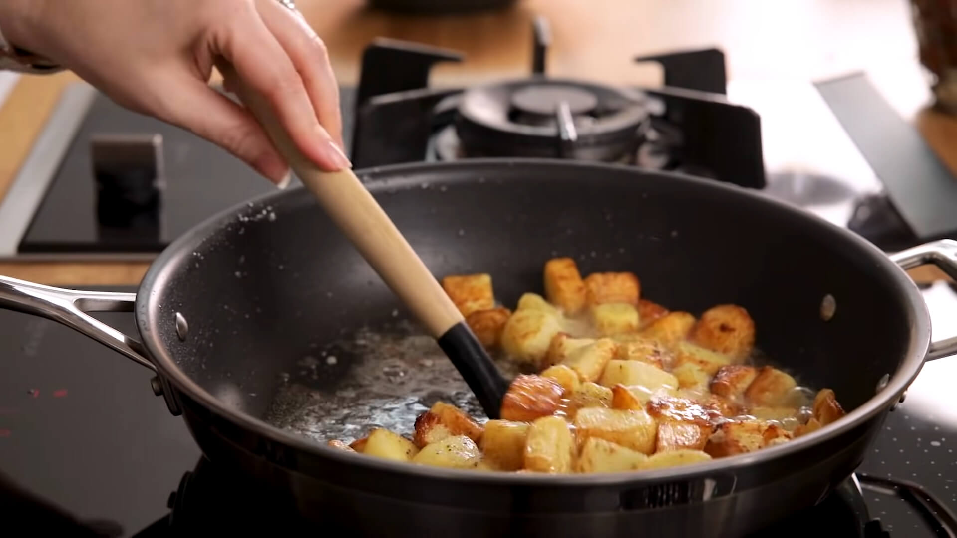 A woman reheating roast potatoes in a skillet