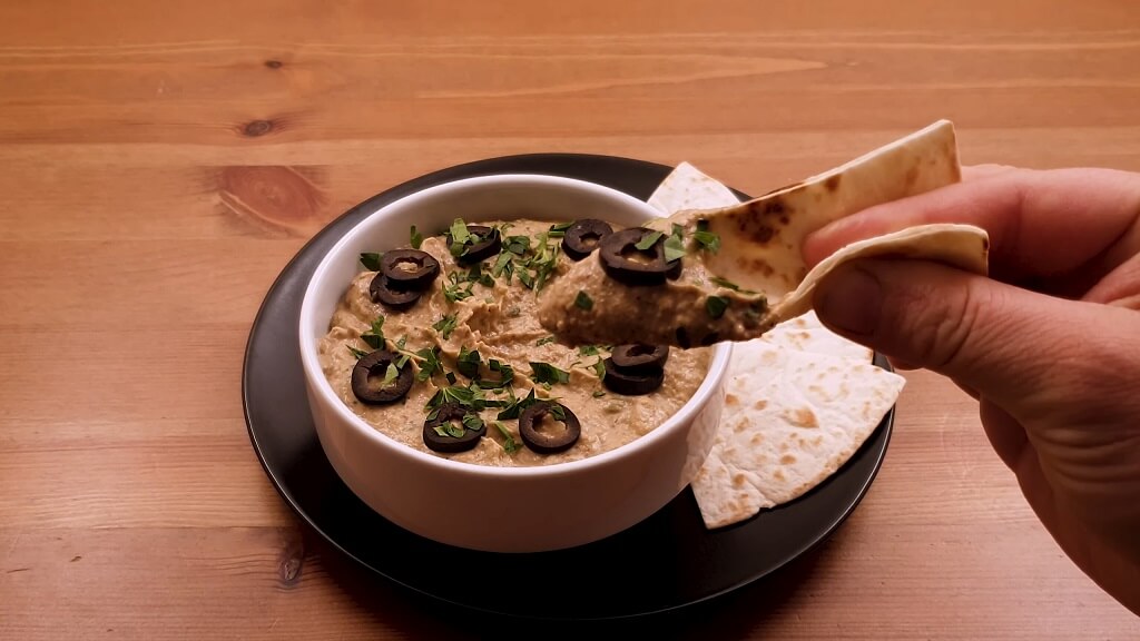 Smoky eggplant spread topped with olives and parsley