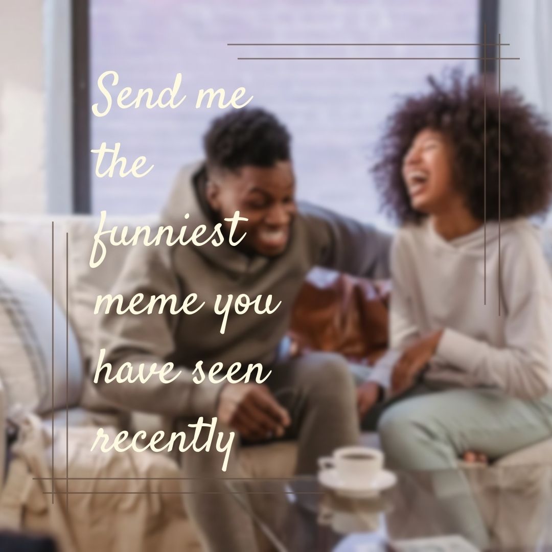  A couple sitting on a couch, laughing heartily