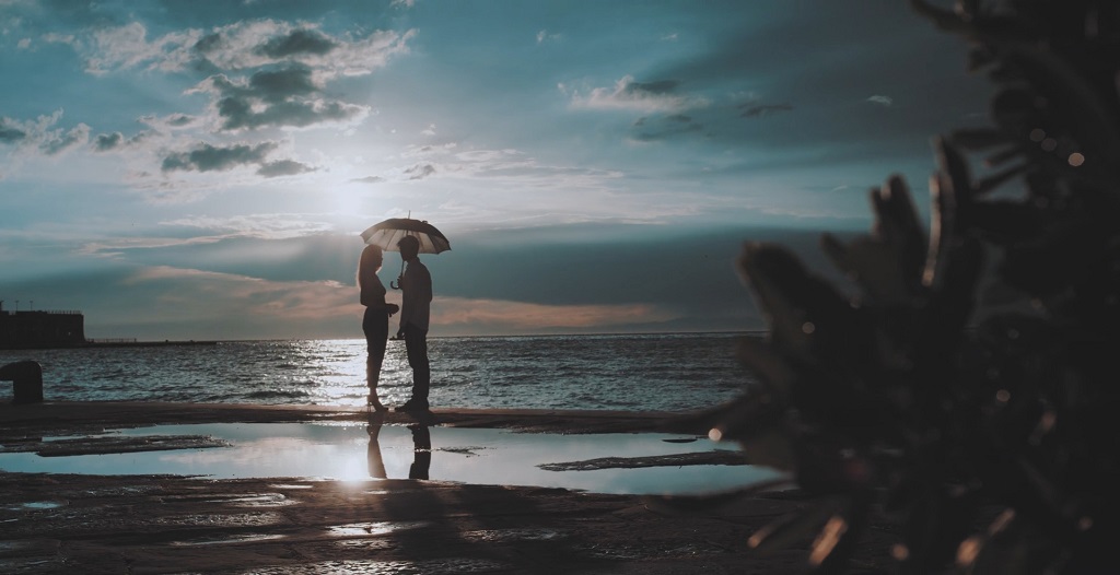 A romantic couple on the beach at sunrise