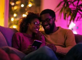 A couple sitting closely on a couch, playing truth or dare