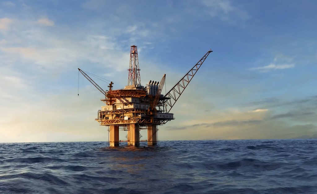 An offshore oil drilling platform in the middle of the ocean during sunset