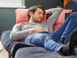 A guy napping on a bed.