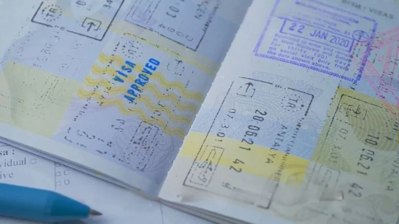 Close-up of a passport with visa approval stamps and travel dates